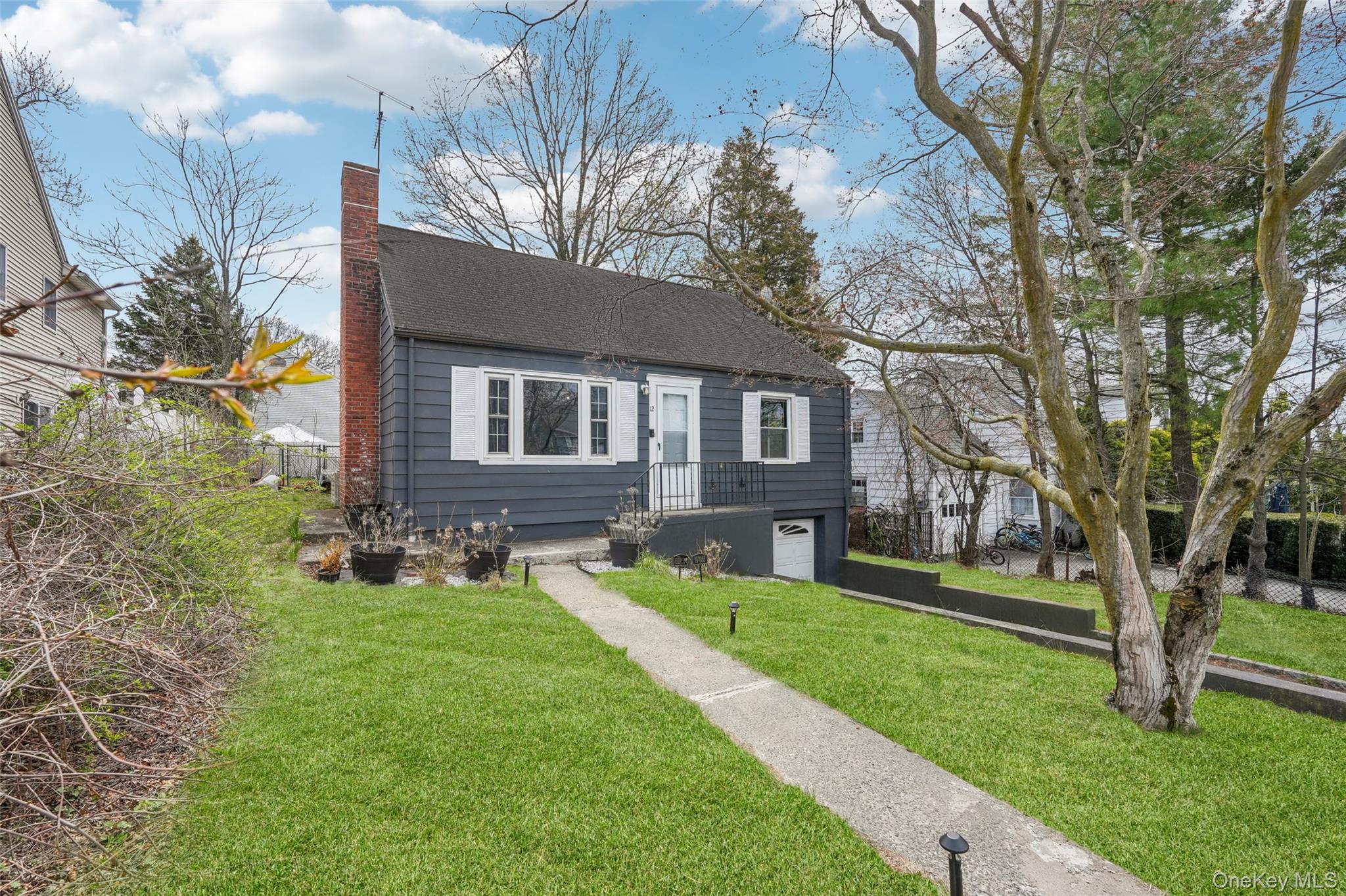 12 Highview Avenue Rye Brook, NY 10573 - Photo 1 of 19 View of front facade featuring a garage, a chimney, a front lawn, driveway, and roof with shingles