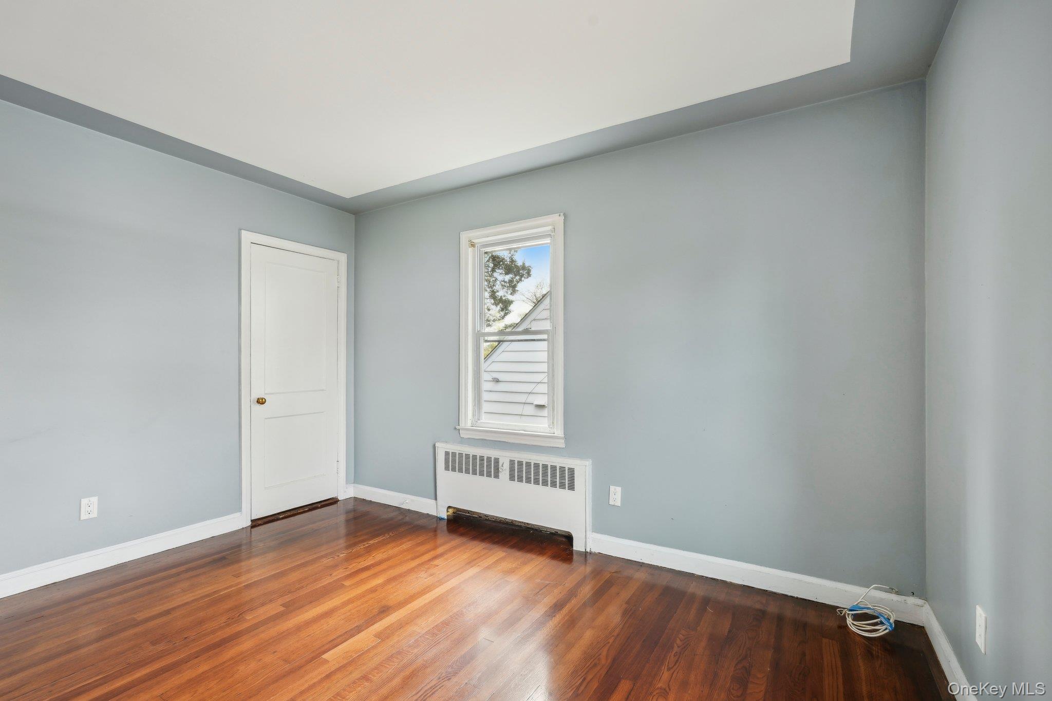 12 Highview Avenue Rye Brook, NY 10573 - Photo 15 of 19 Unfurnished room featuring radiator, wood finished floors, and baseboards