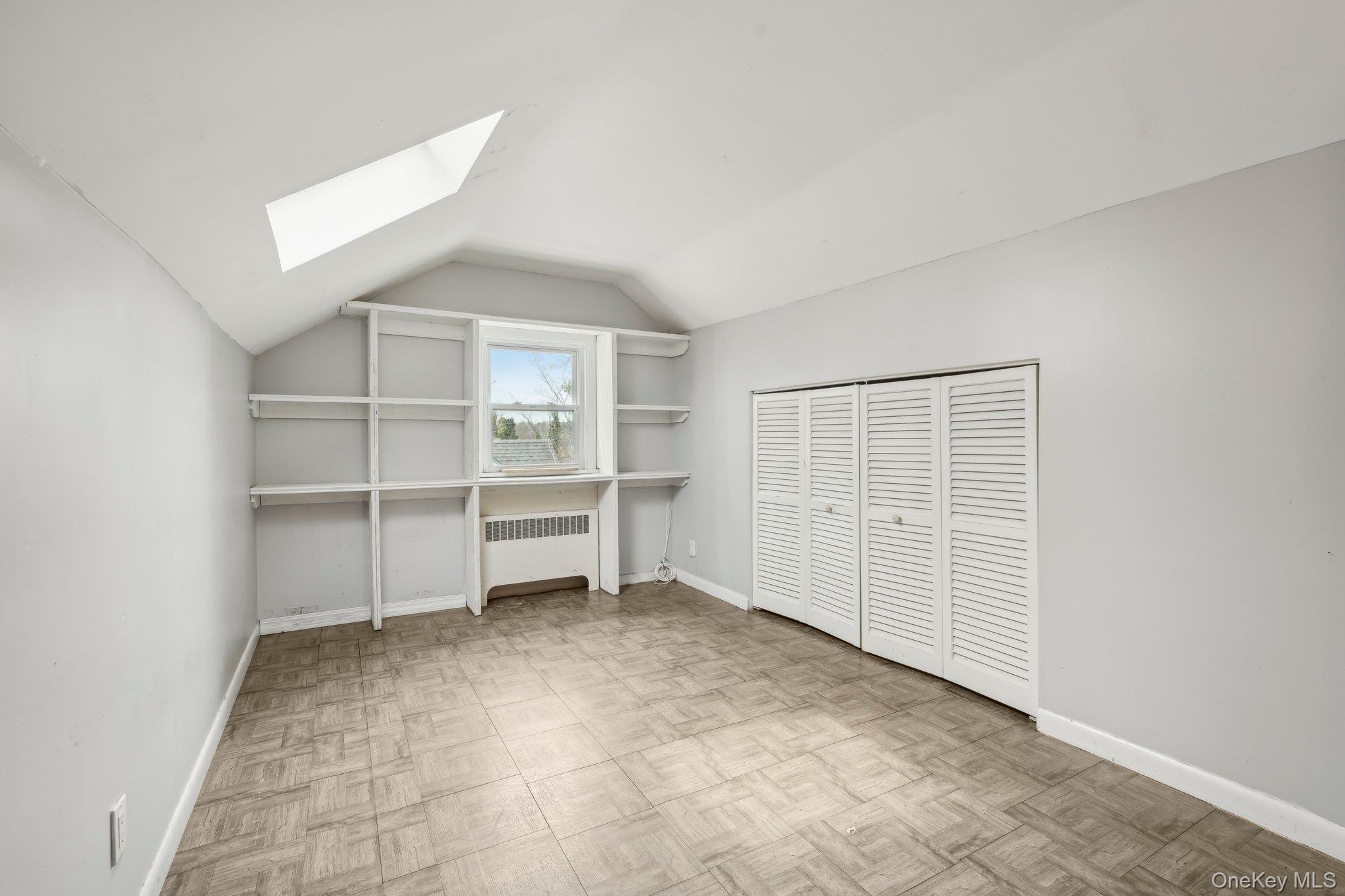 12 Highview Avenue Rye Brook, NY 10573 - Photo 16 of 19 Unfurnished bedroom with radiator heating unit, baseboards, and lofted ceiling with skylight