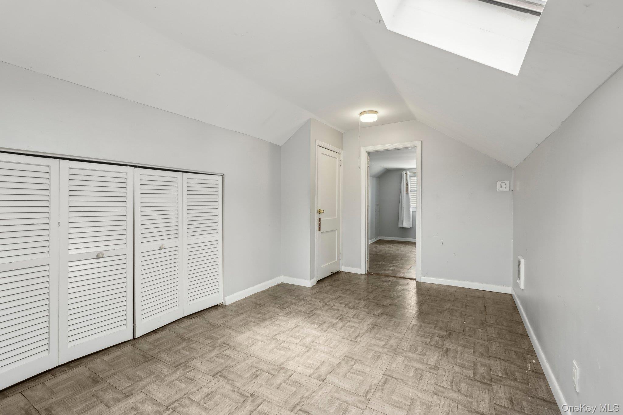 12 Highview Avenue Rye Brook, NY 10573 - Photo 17 of 19 Unfurnished bedroom featuring a closet, baseboards, and lofted ceiling with skylight