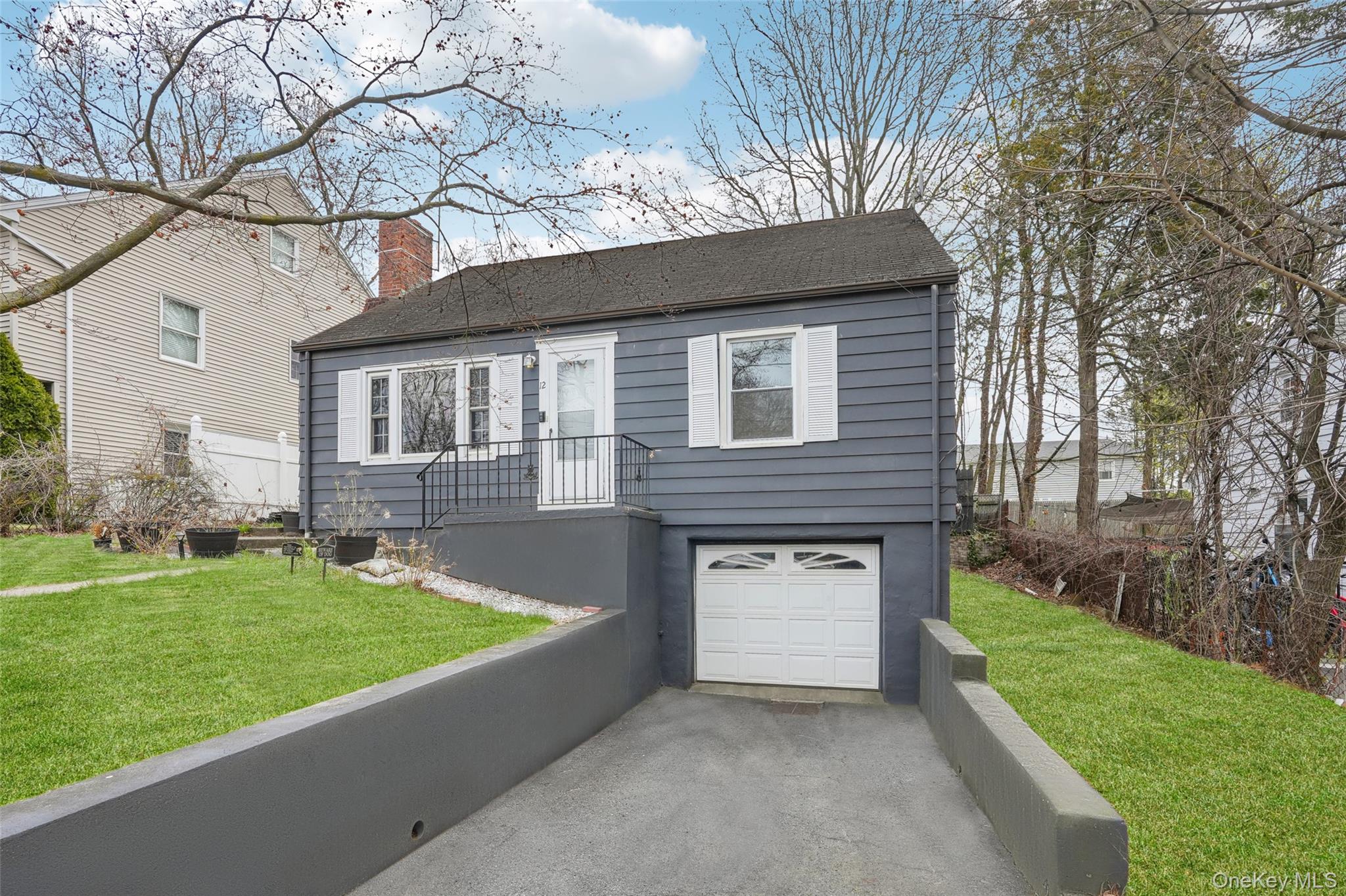 12 Highview Avenue Rye Brook, NY 10573 - Photo 2 of 19 View of front of home with a front yard, driveway, a garage, and a chimney
