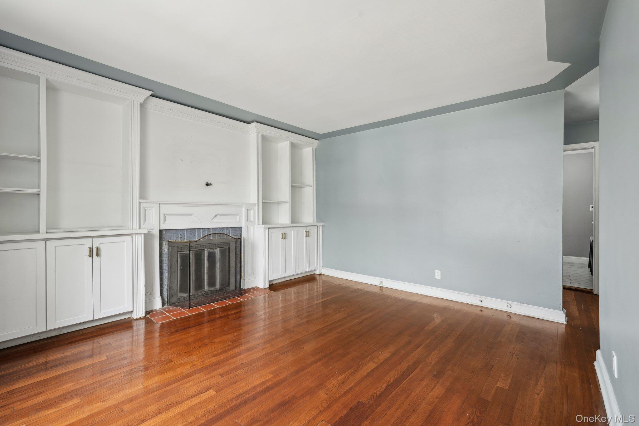 12 Highview Avenue Rye Brook, NY 10573 - Photo 6 of 19 Unfurnished living room with a tiled fireplace, baseboards, and wood finished floors