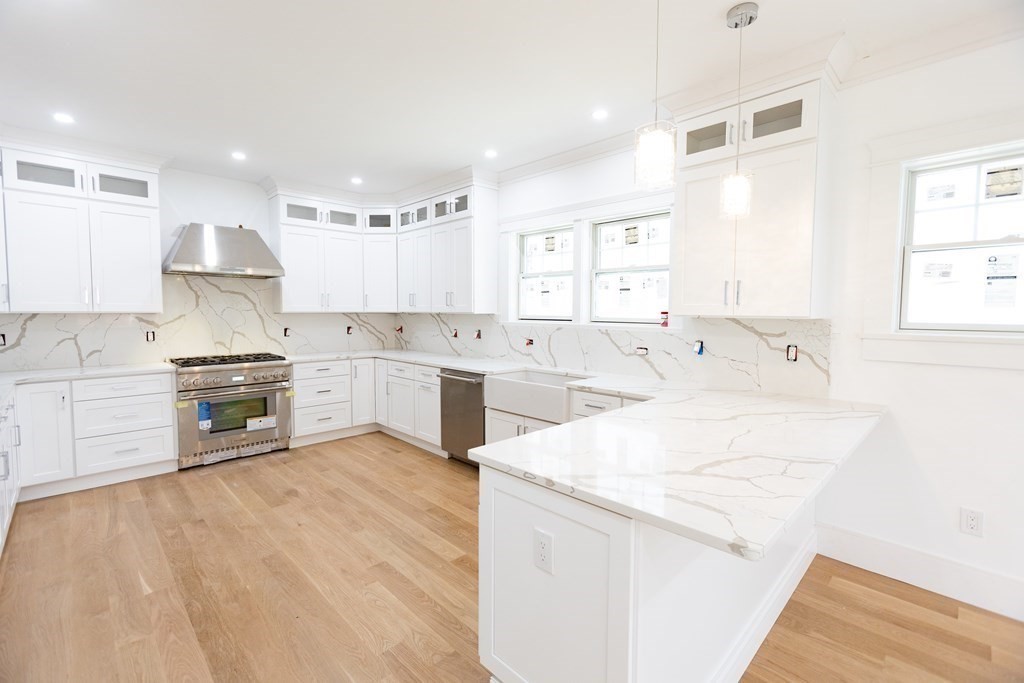 14 Lexington Road Wellesley, MA 02482 - Photo 7 of 19 a large white kitchen with a stove a sink dishwasher and a refrigerator with wooden floor