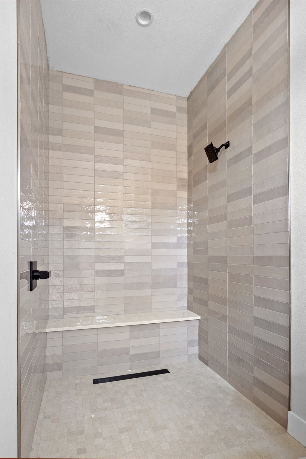903 Flint Ridge Trail Georgetown, TX 78628 - Photo 19 of 39 Tiled shower enclosure featuring a linear drain, integrated bench seating, and matte black fixtures