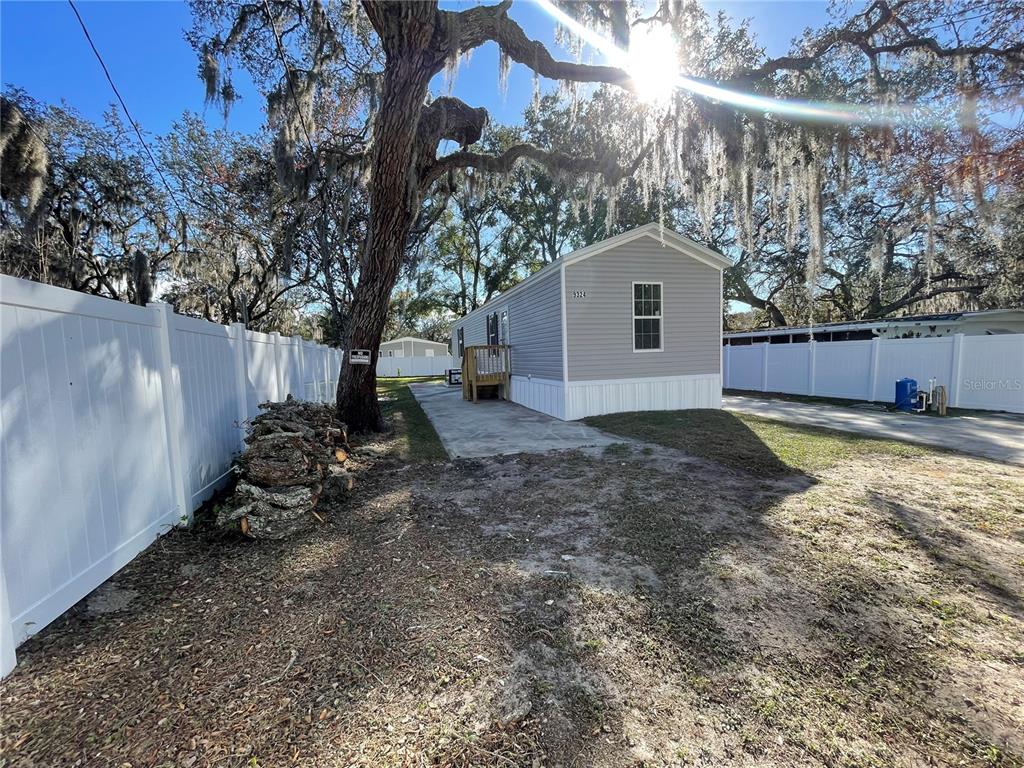 a view of a house with a yard and large tree
