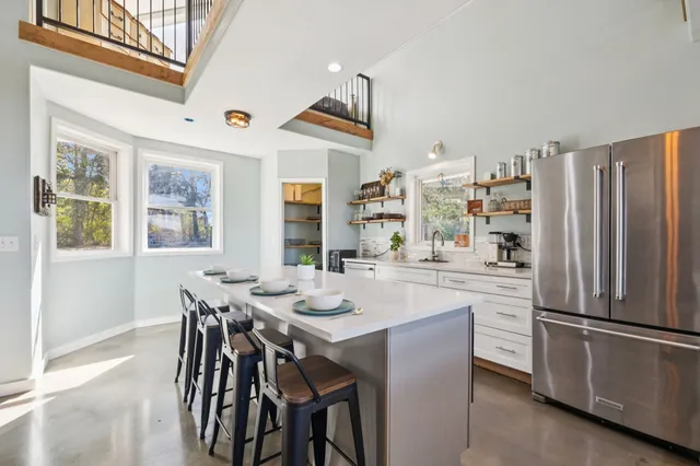 a view of a house with a big yard and large trees