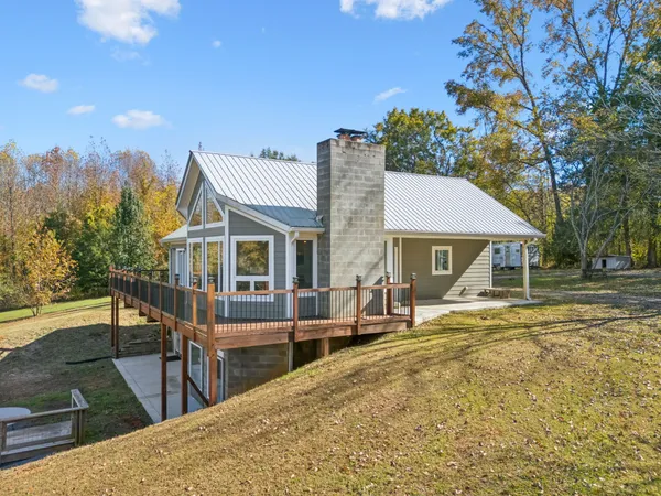 a kitchen with stainless steel appliances granite countertop a dining table chairs and refrigerator