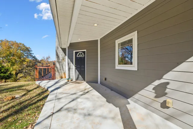 a kitchen with stainless steel appliances granite countertop a stove a refrigerator a dining table and chairs with wooden floor