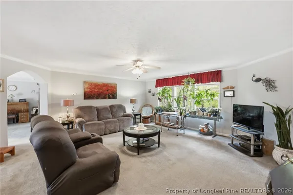 a living room with furniture a flat screen tv and a large window