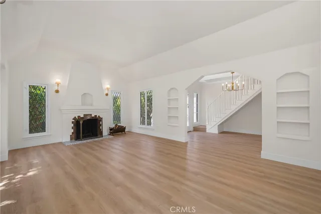 wooden floor fireplace and windows in an empty room