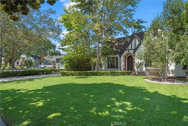 a view of a house with a big yard and large trees