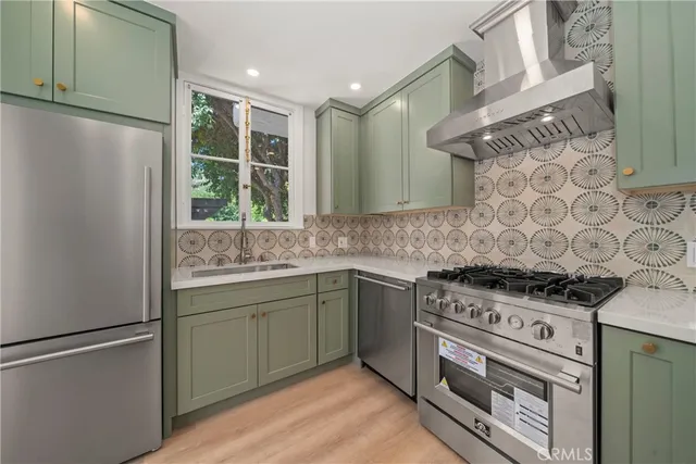 a kitchen with stainless steel appliances granite countertop a stove a sink and a refrigerator