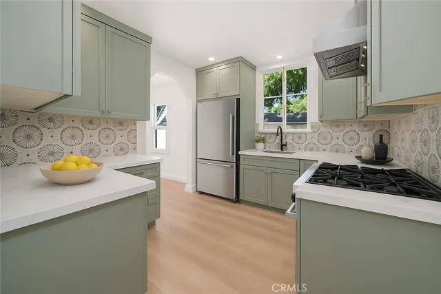 a kitchen with stainless steel appliances granite countertop a sink stove and refrigerator
