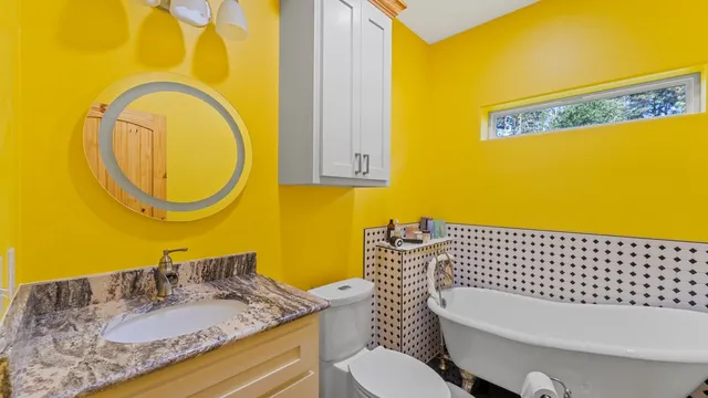 a bathroom with a granite countertop toilet sink and mirror