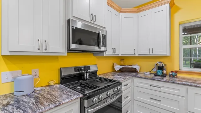 a kitchen with stainless steel appliances granite countertop a stove a microwave and cabinets