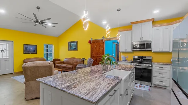 a kitchen with stainless steel appliances granite countertop a stove refrigerator and microwave