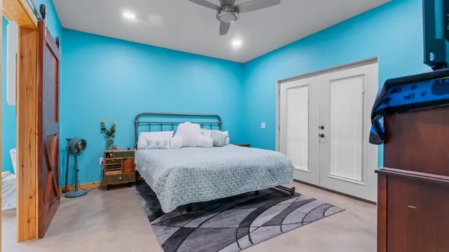 a bedroom with a bed and a refrigerator