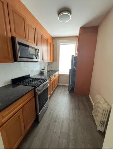 a kitchen with stainless steel appliances granite countertop a stove a sink and a refrigerator