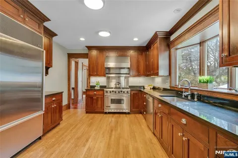 a large kitchen with stainless steel appliances granite countertop a stove a sink dishwasher and a refrigerator