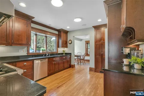 a kitchen with stainless steel appliances granite countertop sink stove refrigerator and cabinets
