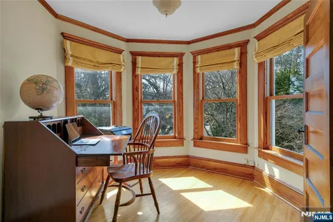 a view of a workspace with furniture and a window