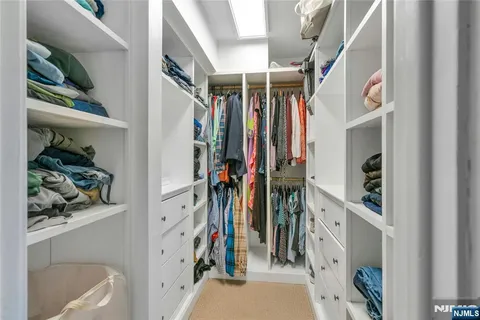 a view of walk in closet with clothes and shoes
