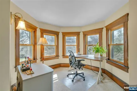 a view of a livingroom with workspace and a large window