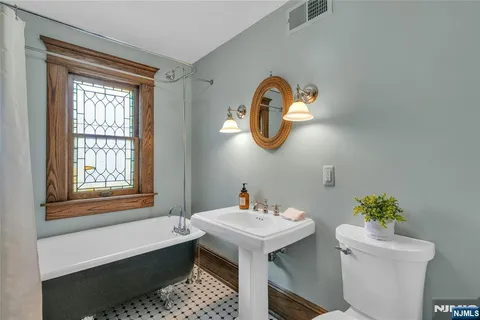 a bathroom with a sink a toilet and a window