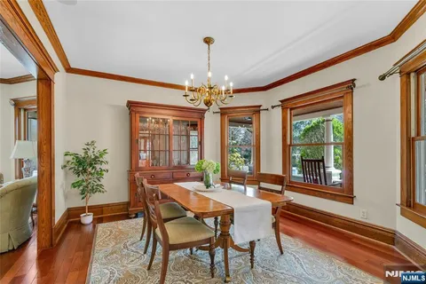 a dining room with furniture a chandelier and wooden floor