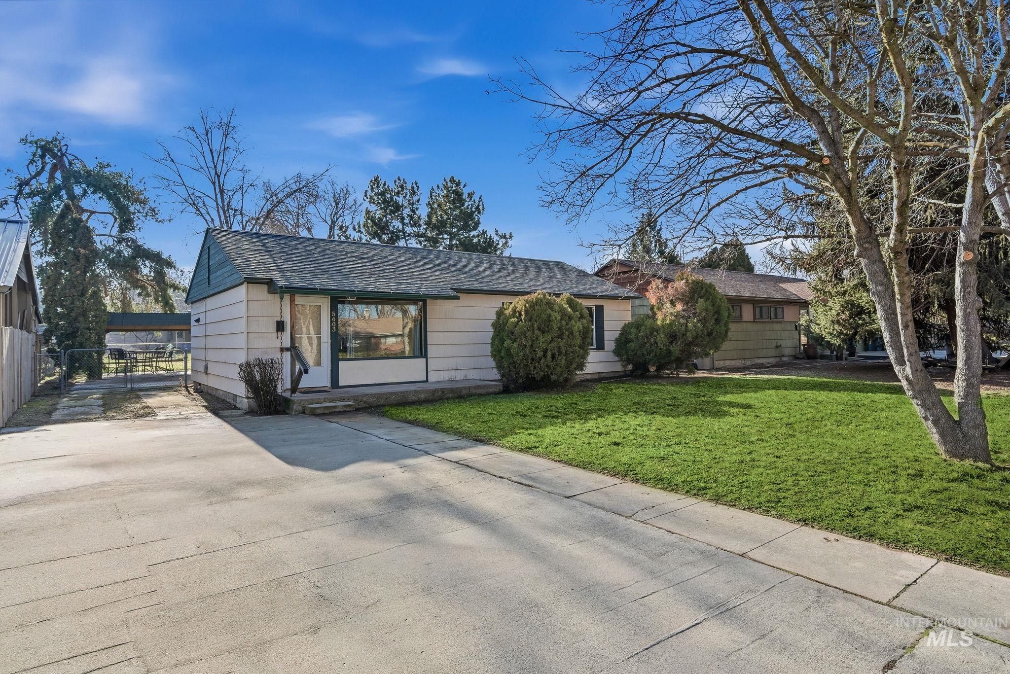 Ranch-style home featuring roof with shingles and a gate