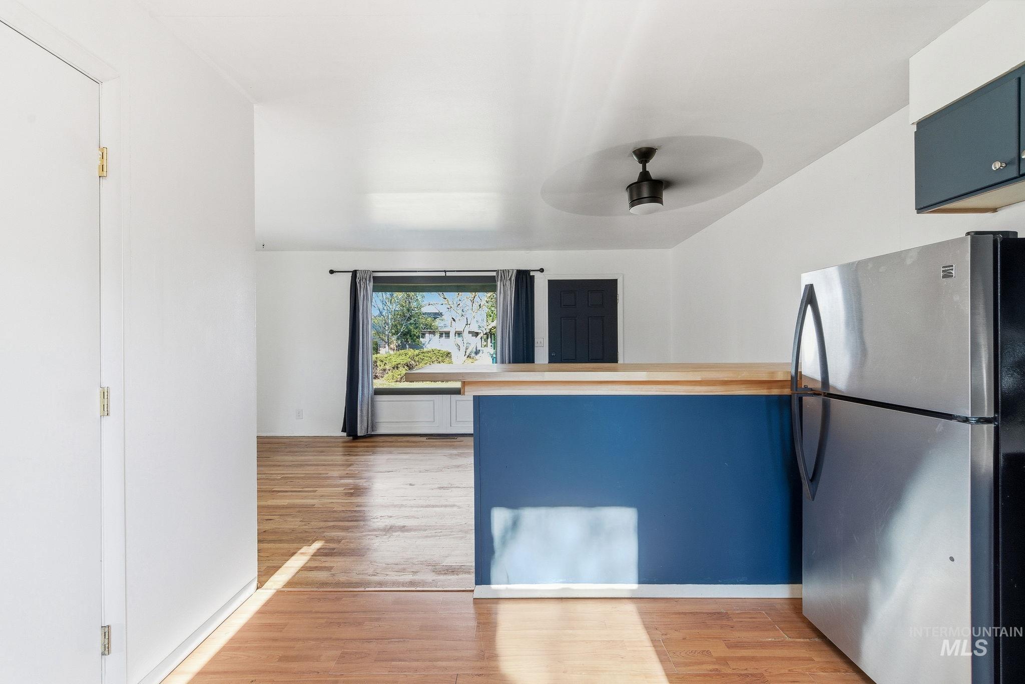 5603 West Edson Street Boise, ID 83705 - Photo 21 of 43 Kitchen featuring blue cabinets, freestanding refrigerator, light wood-style flooring, a peninsula, and ceiling fan