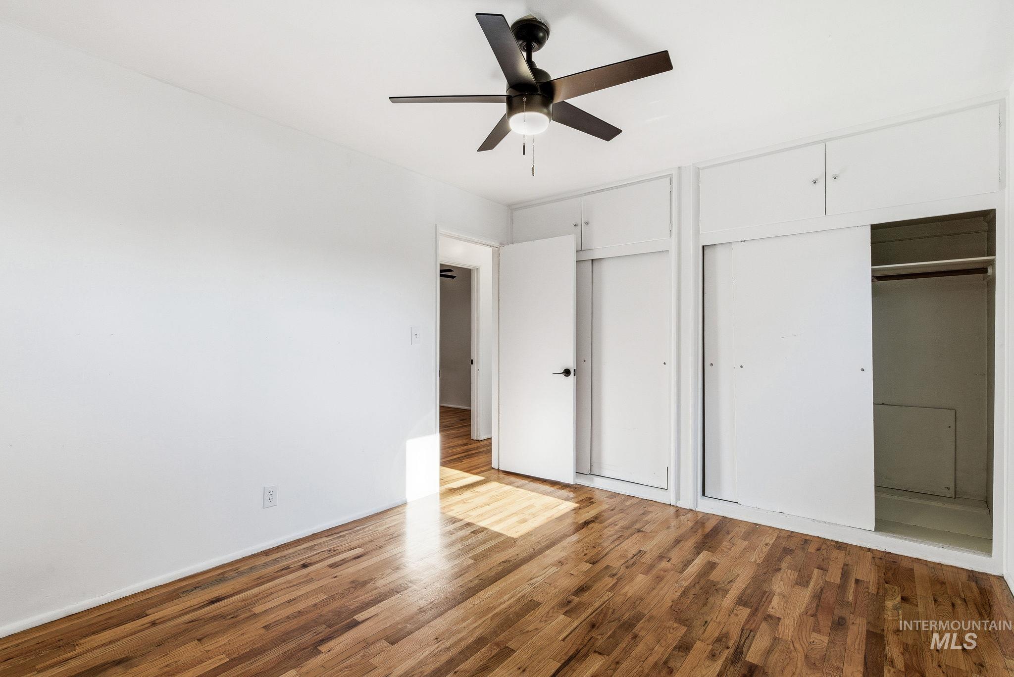 5603 West Edson Street Boise, ID 83705 - Photo 31 of 43 Unfurnished bedroom featuring two closets, wood finished floors, and a ceiling fan