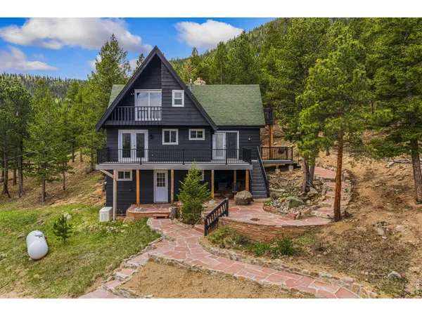 a view of a big house with wooden fence