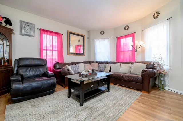 a living room with furniture a window and a flat screen tv