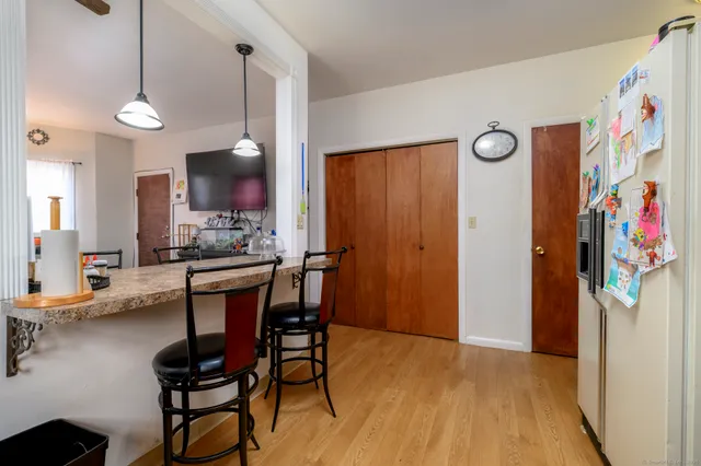 a kitchen with stainless steel appliances a dining table chairs refrigerator and sink