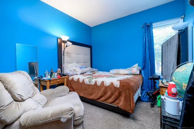 a bedroom with bed and a mirror