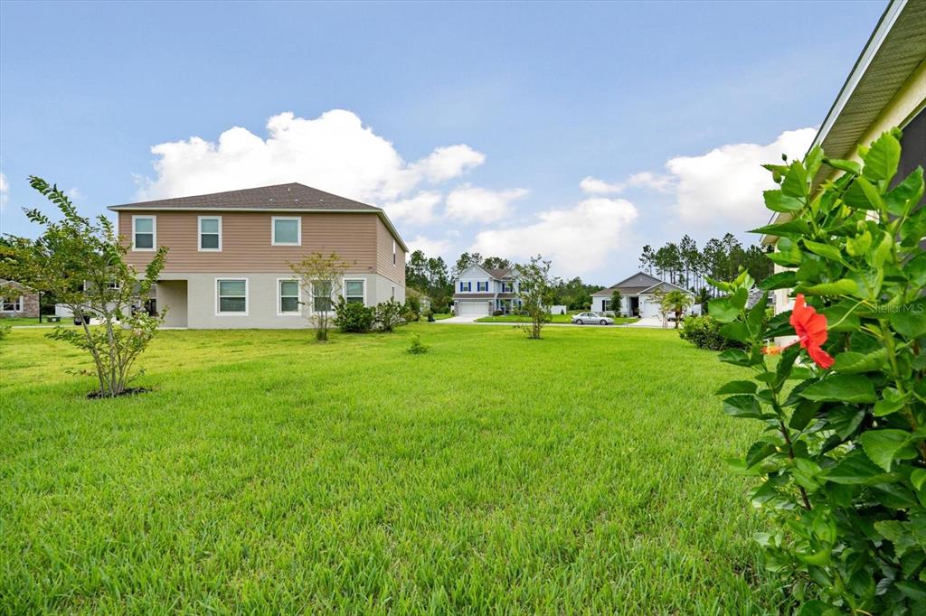 33 Ridge Road Palm Coast, FL 32137 - Photo 19 of 31 a aerial view of a house with a big yard and potted plants
