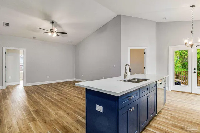a kitchen with a stove and wooden floor