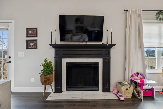 a living room with a fireplace and wooden floor