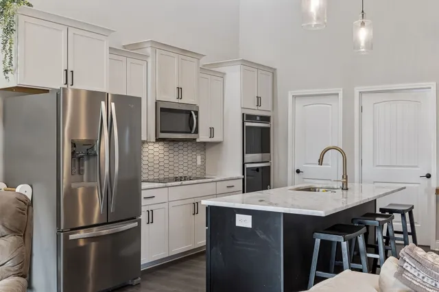 a kitchen with stainless steel appliances a refrigerator stove microwave and sink