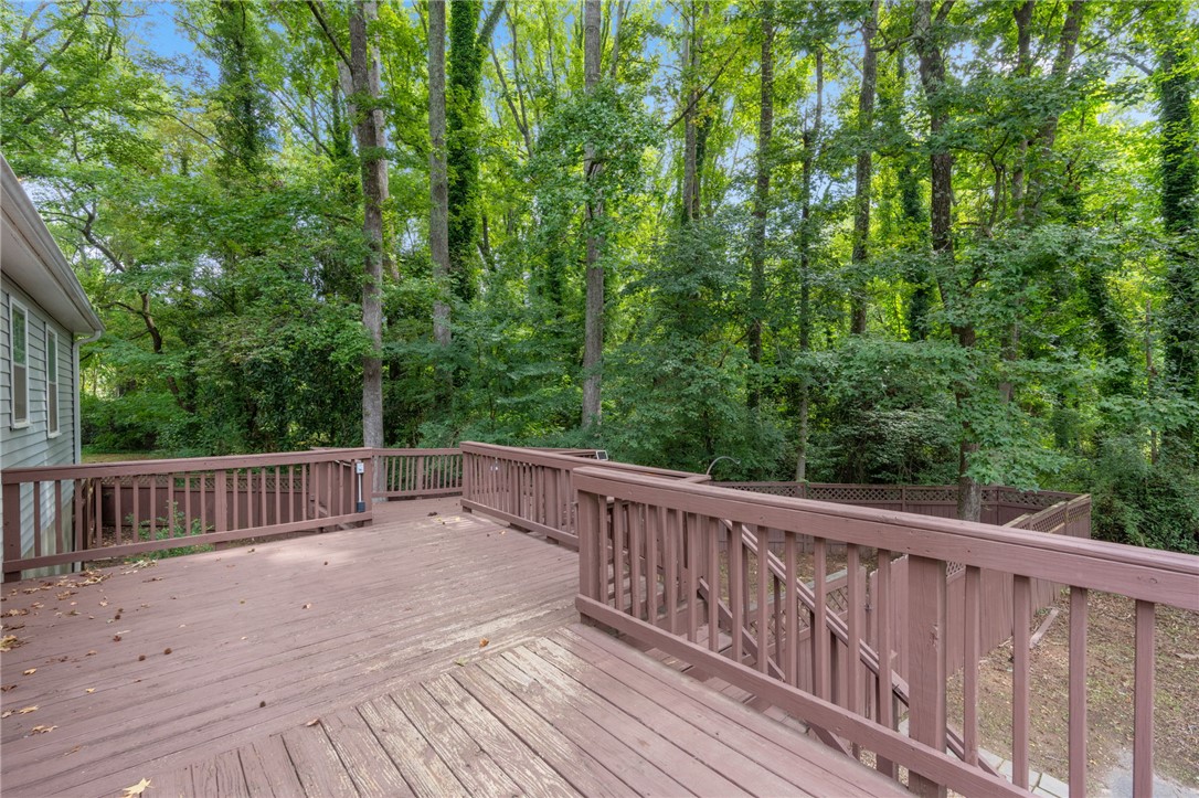 98 Blue Ridge Drive Clemson, SC 29631 - Photo 25 of 32 An outdoor wooden deck overlooks a lush, wooded backyard setting.