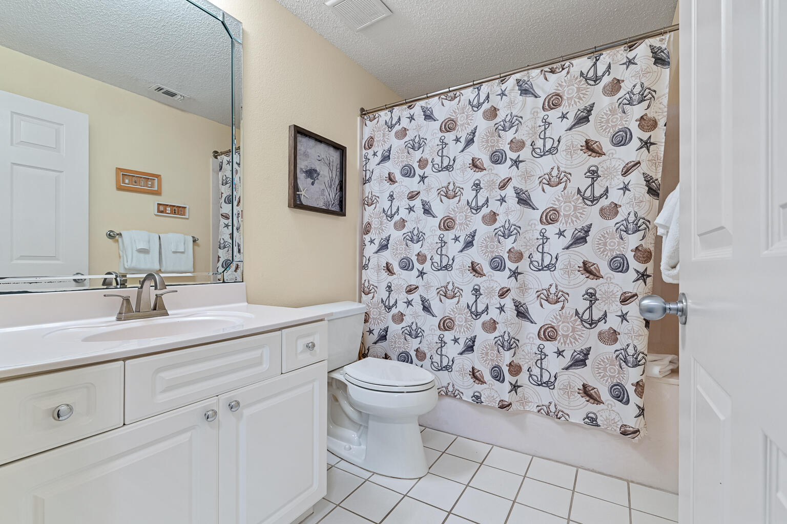 8499 Gulf Boulevard, Unit 303 Navarre, FL 32566 - Photo 25 of 52 a bathroom with a granite countertop sink a toilet and a mirror