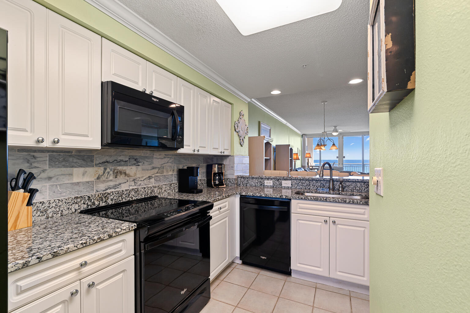 8499 Gulf Boulevard, Unit 303 Navarre, FL 32566 - Photo 33 of 52 a kitchen with a sink stove and microwave