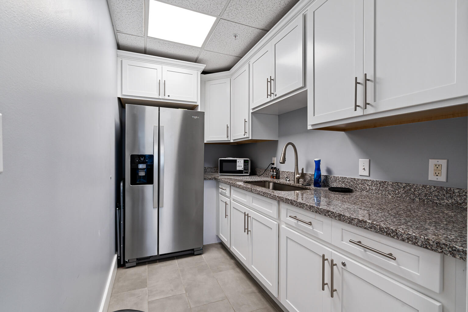 8499 Gulf Boulevard, Unit 303 Navarre, FL 32566 - Photo 36 of 52 a kitchen with stainless steel appliances granite countertop a refrigerator sink and cabinets