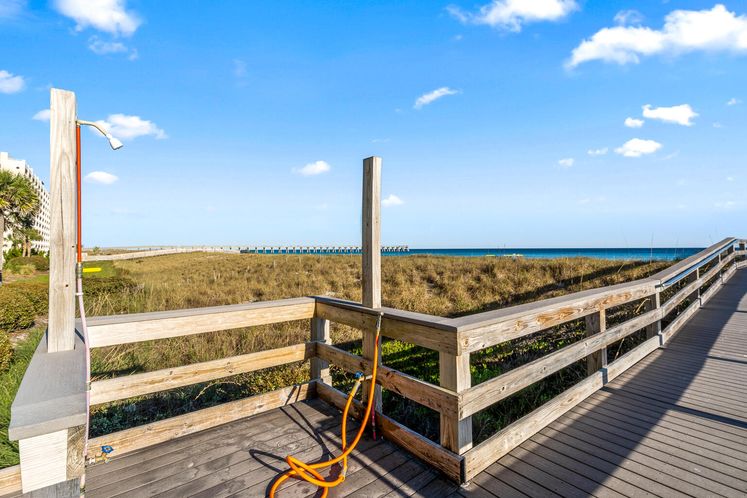 8499 Gulf Boulevard, Unit 303 Navarre, FL 32566 - Photo 40 of 52 a view of a balcony with wooden floor and fence