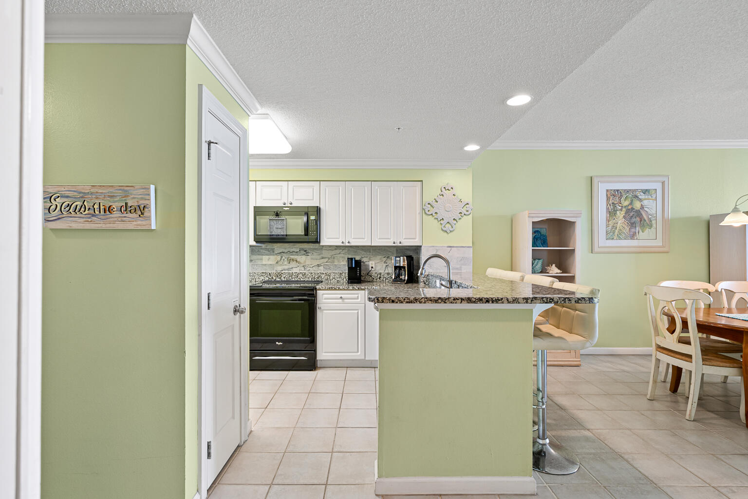 8499 Gulf Boulevard, Unit 303 Navarre, FL 32566 - Photo 8 of 52 a kitchen with stainless steel appliances granite countertop a refrigerator a stove top oven a sink dishwasher and white cabinets with wooden floor