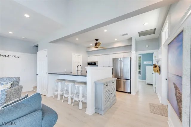 a kitchen with stainless steel appliances kitchen island granite countertop a refrigerator and a cabinets