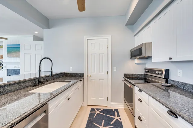 a kitchen with granite countertop a sink and a stove top oven