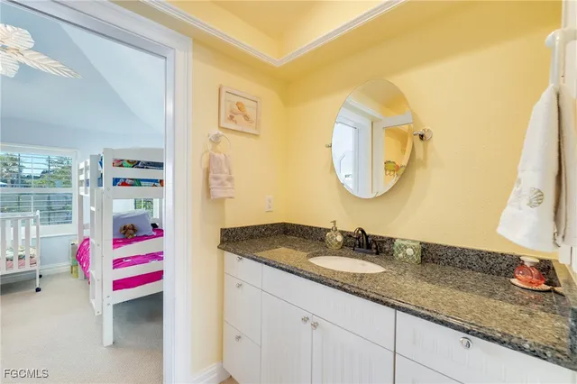 a bathroom with a granite countertop double vanity sink and a mirror