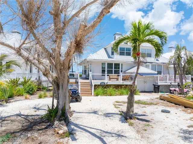 a front view of a house with garden and trees